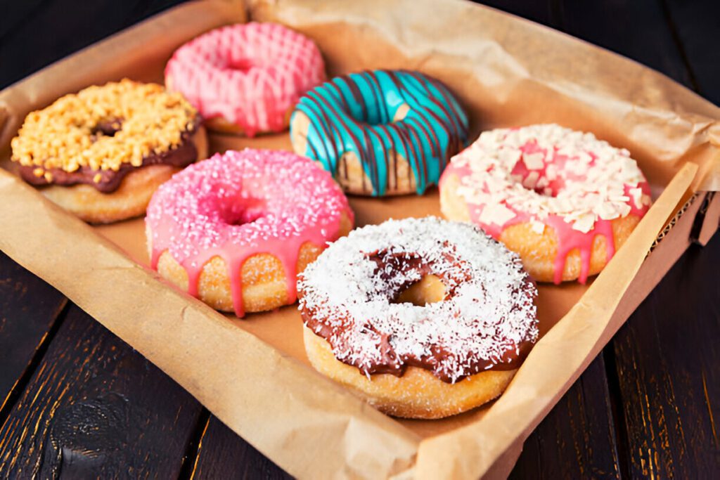 Freshly made homemade donuts using donut mix, glazed and topped with colorful sprinkles"